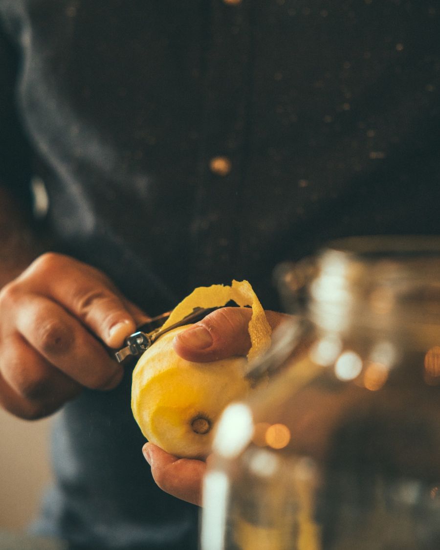 Mains zestant un citron à la main